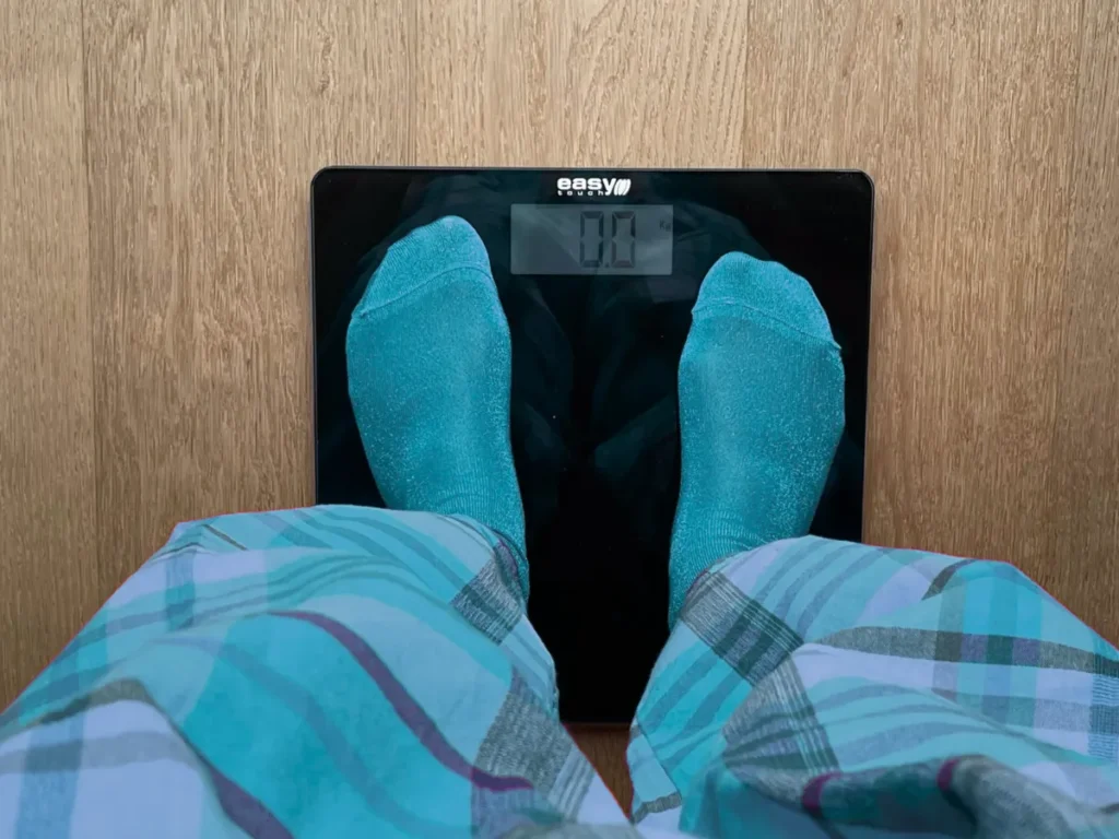 Pacjent stoi na wadze - leczenie otyłości w Krakowie - Przylądek Równowagi